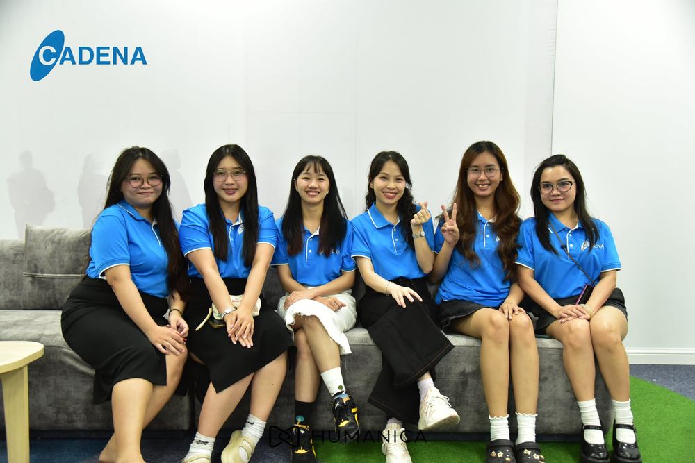 Six Cadena team members in blue uniforms posing on a sofa on the new floor